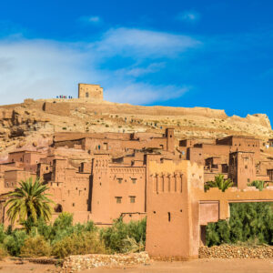 Historic mudbrick Kasbah of Ait Benhaddou under a blue sky.